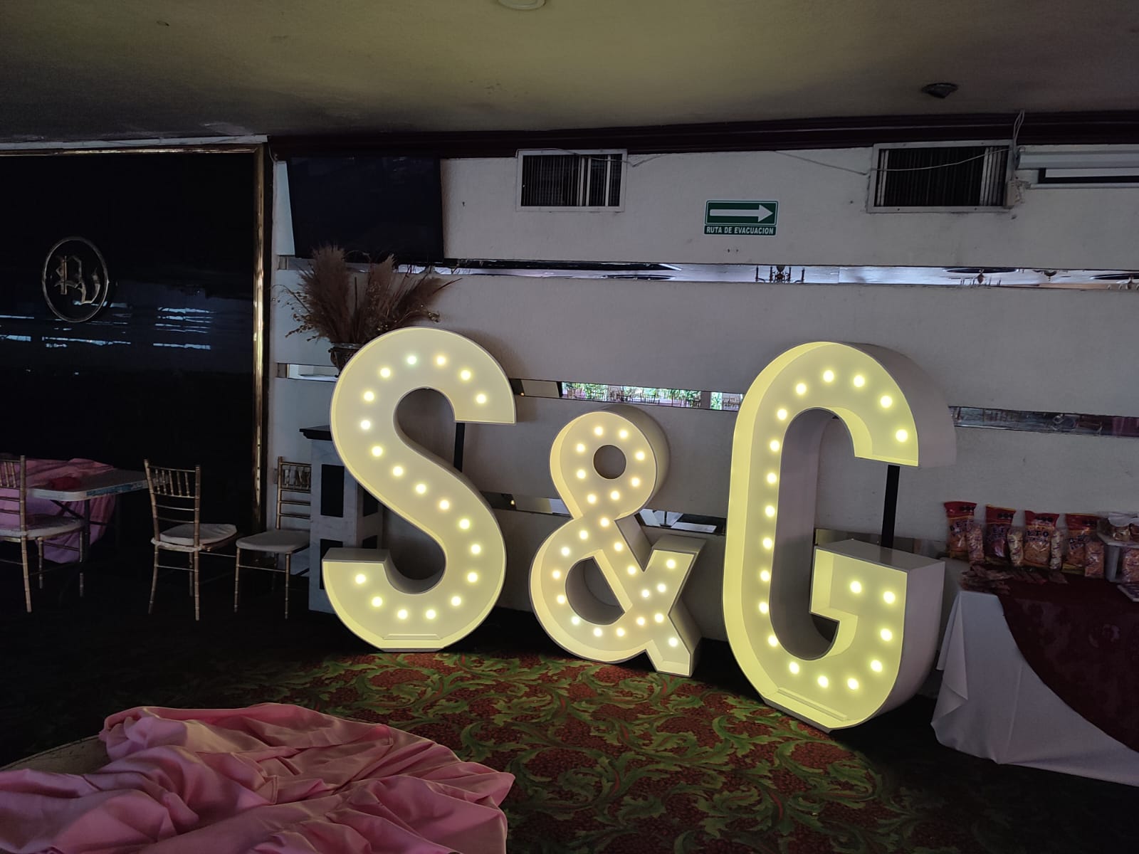 Iniciales gigantes iluminadas S y G en una boda