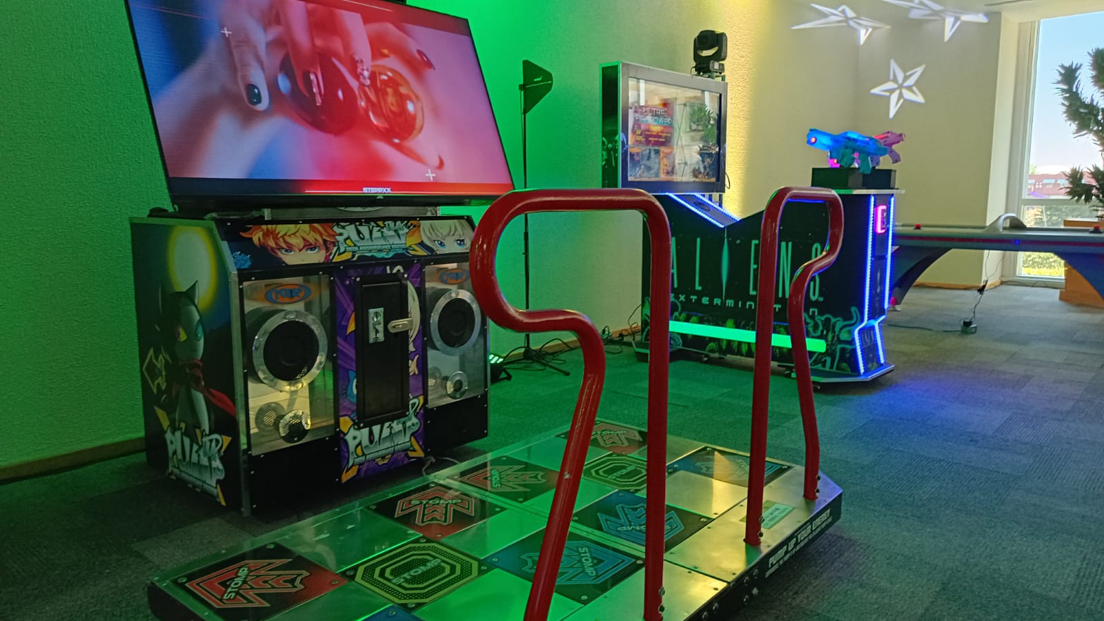 Zona de videojuegos con máquina de baile y juegos arcade